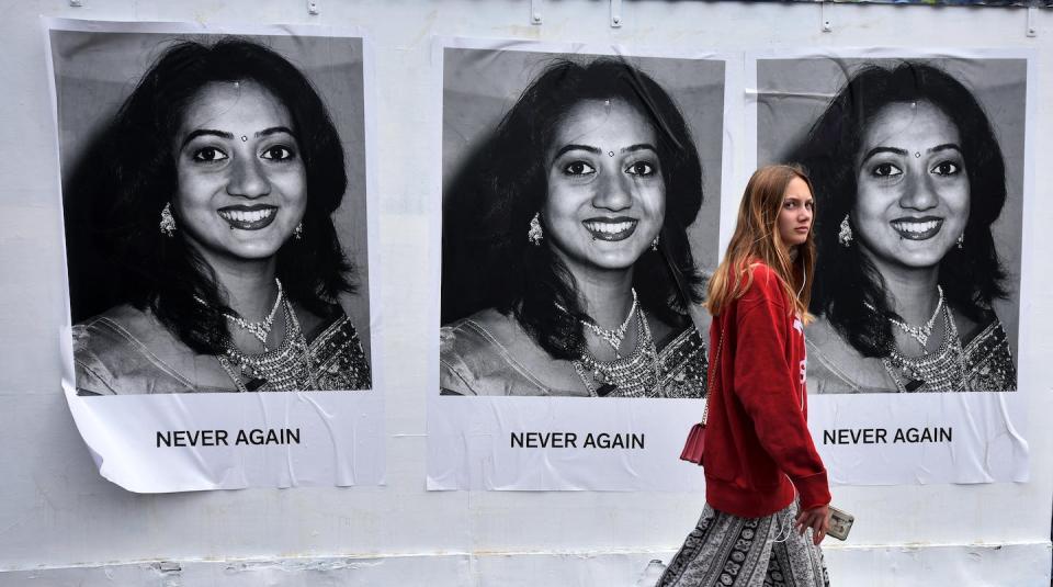 A woman walks past posters showing Savita Halappanavar, a woman who died in Ireland in 2012 after doctors did not intervene and end her unviable pregnancy, resulting in a fatal infection. <a href="https://media.gettyimages.com/photos/young-woman-walks-past-art-work-featuring-savita-halappanavar-which-picture-id962636306?s=2048x2048" rel="nofollow noopener" target="_blank" data-ylk="slk:Charles McQuillan/Getty Images;elm:context_link;itc:0;sec:content-canvas" class="link ">Charles McQuillan/Getty Images</a>