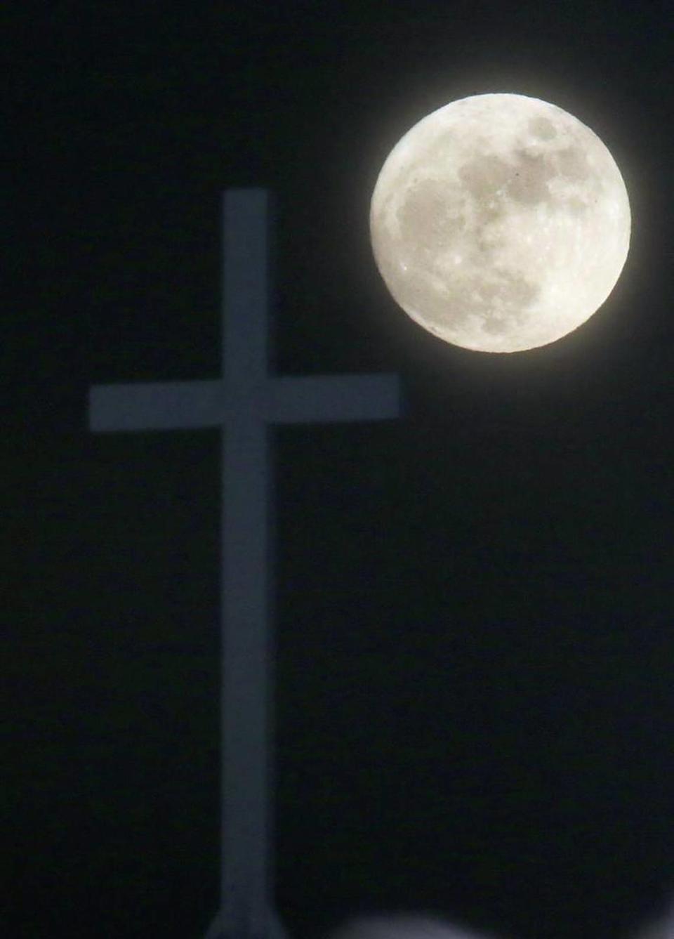 The Long Night Moon rises behind a cross at Christ Community Church in Lawrence, Kan., Thursday, Dec. 24, 2015. When the moon turns full, at 5:11am cst., it will be the first full moon to fall on Christmas day since 1977. Named the Long Night Moon because it’s the first full moon to follow the winter solstice, it’s also known as the Cold Moon.