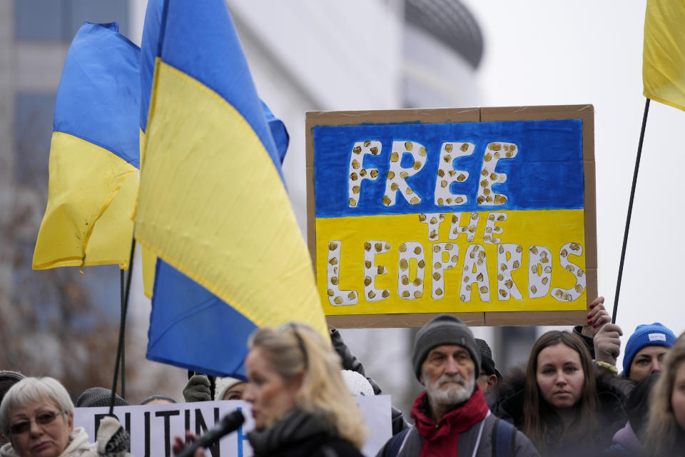 Protestors hold signs and wave Ukrainian flags during a demonstration in support of Ukraine outside of an EU foreign ministers meeting at the European Council building in Brussels on Monday, Jan. 23, 2023. (AP Photo/Virginia Mayo)