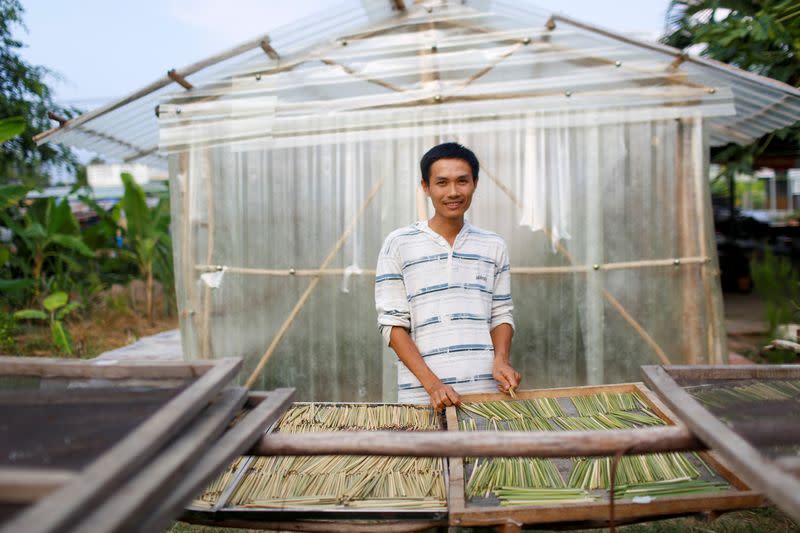 Tran Minh Tien, owner of 3T shop that makes grass straws, poses for a portrait in front of his workshop in Long An province