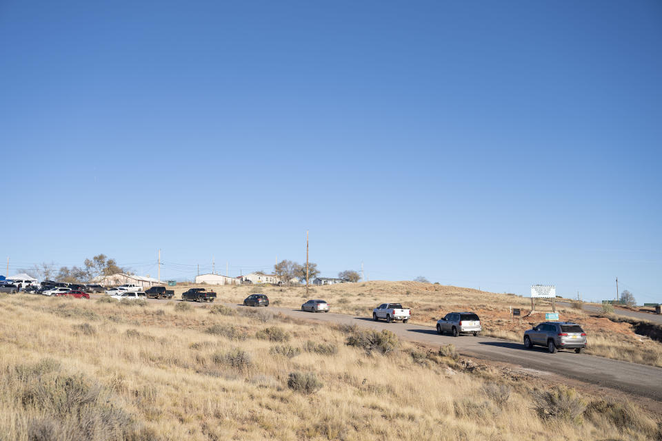 A line of cars forms at the Churchrock Chapter House in Church Rock, N.M., as voters arrive to place their ballots Tuesday, Nov. 8, 2022. Navajo voters are deciding who they want to be their next president, a position that wields influence nationally because of the tribe's hefty population and the size of it reservation in the U.S. Southwest. (AP Photo/William C. Weaver IV)