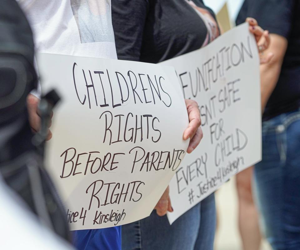 Family, friends, and other care givers hold signs calling for DCS reform after 5-year-old Kinsleigh Welty died April 9 of severe malnutrition, after being returned to her mother, during a gathering of family and friends to bring attention to DCS reform at the Indiana Statehouse on Sunday, April 28, 2024, in Indianapolis.