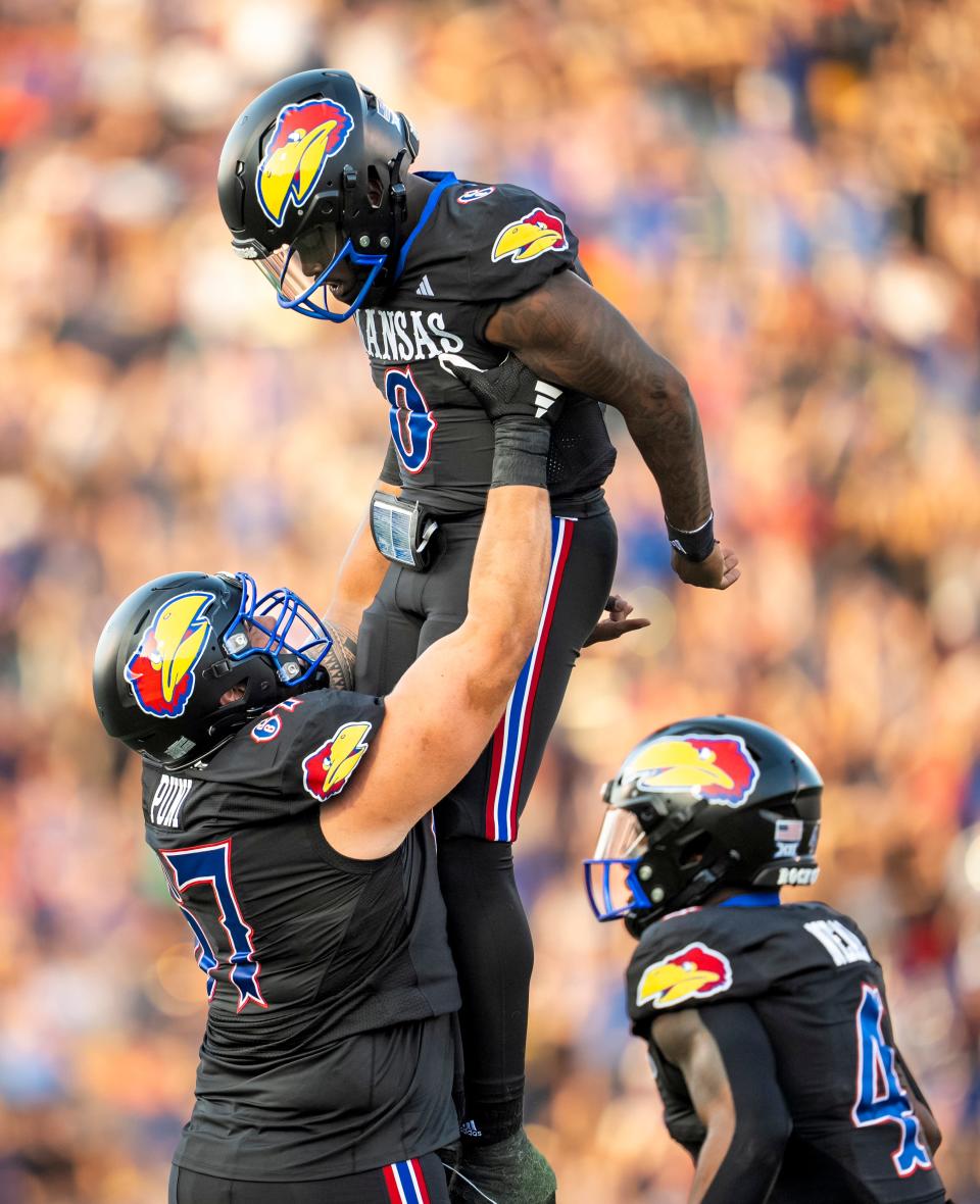 Kansas football quarterback Jalon Daniels (6) celebrates with offensive lineman Dominick Puni (67) after a touchdown on Sept. 8, 2023 during a game against Illinois at David Booth Kansas Memorial Stadium.