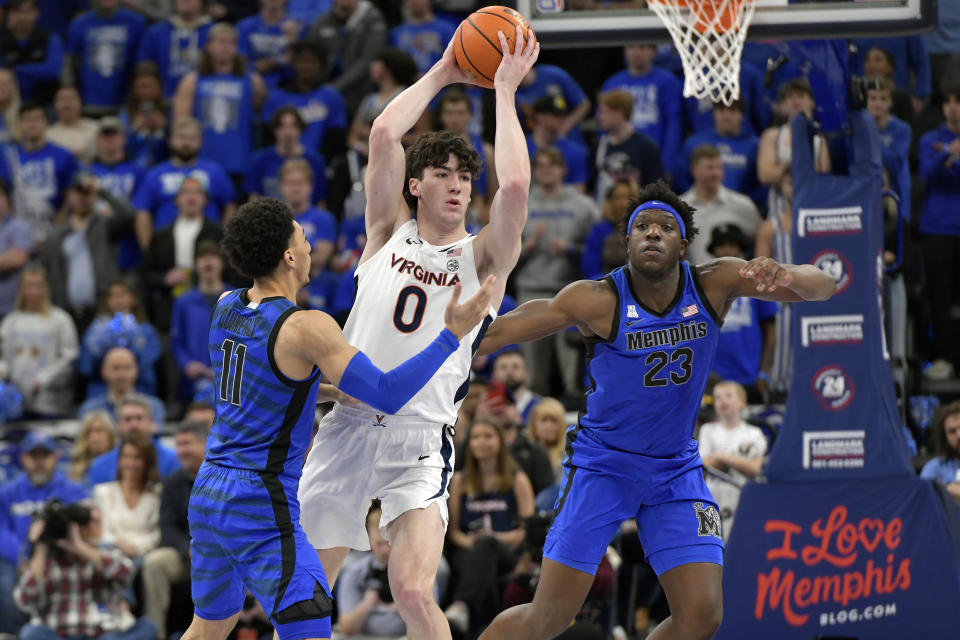 Virginia forward Blake Buchanan (0) handles the ball between Memphis guard Jahvon Quinerly (11) and forward Malcolm Dandridge (23) during the first half of an NCAA college basketball game Tuesday, Dec. 19, 2023, in Memphis, Tenn. (AP Photo/Brandon Dill)