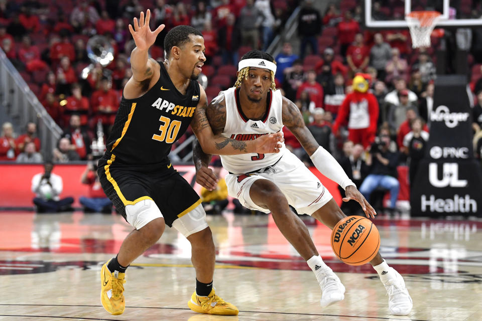 Louisville guard El Ellis (3) attempts to get past Appalachian State guard Tyree Boykin (30) during the second half of an NCAA college basketball game in Louisville, Ky., Tuesday, Nov. 15, 2022. Appalachian St. won 61-60. (AP Photo/Timothy D. Easley)