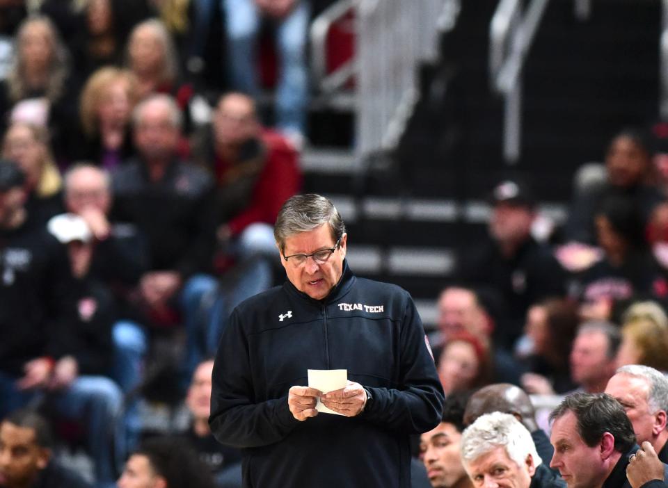 Texas Tech coach Mark Adams looks at his notes during a Big 12 Conference game against Texas earlier this month at the United Supermarkets Arena in Lubbock. On Tuesday, the Red Raiders will face the Kansas Jayhawks.