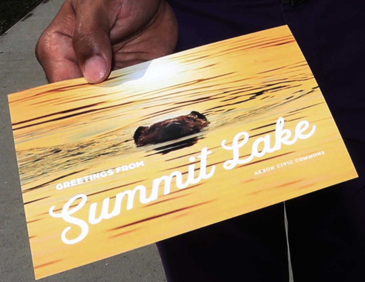 Roger Riddle shows a postcard from the Akron Civic Commons Summit Lake Postcard Project at Summit Lake in Akron.