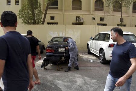 A Kuwaiti police officer stands next to a sniffer dog as investigations take place after a suicide bomb attack at the Imam Sadiq Mosque in the Al Sawaber area of Kuwait City June 26, 2015. REUTERS/Jassim Mohammed