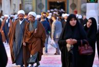 In this Sunday, Feb. 2, 2020 photo, Shiite seminary students and Shiite Muslim worshippers visit the holy shrine of Imam Ali, the son-in-law, and cousin of the Prophet Muhammad and the first Imam of the Shiites, in Najaf, Iraq. Grand Ayatollah Ali al-Sistani, Iraq’s top Shiite cleric, turns 90 this year, and when he recently had surgery it sent chills around the country and beyond. What happens when al-Sistani is gone? Iran is likely to try to exploit the void to gain followers among Iraq’s Shiites. Standing in its way is the Hawza, the centuries-old institution of religious learning which al-Sistani heads and which follows its own tradition-bound rules. (AP Photo/Hadi Mizban)