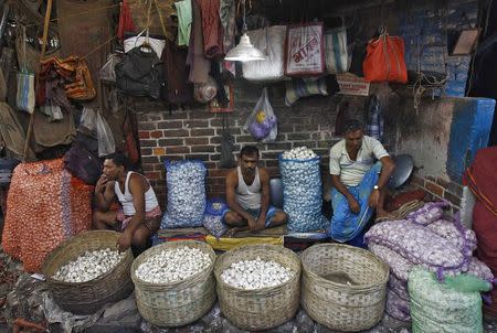 Vendors wait for customers at their stall selling garlic at a wholesale vegetable market in Kolkata February 27, 2015. REUTERS/Rupak De Chowdhuri