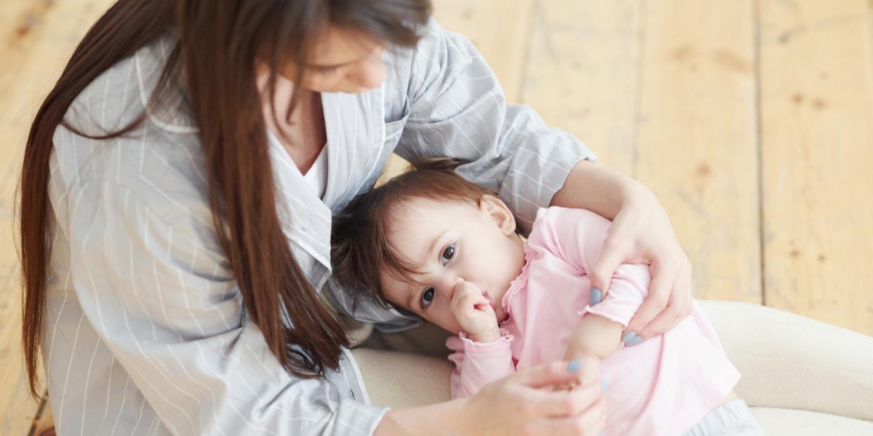 toddler sucking their thumb on mother's lap Gentle ways to wean off the pacifier or thumb-sucking