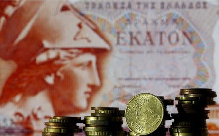Euro coins are seen in front of a displayed of Head of Athena on 100 Drachma old Greece banknote in this photo illustration taken in Zenica, Bosnia and Herzegovina, June 30, 2015. REUTERS/Dado Ruvic