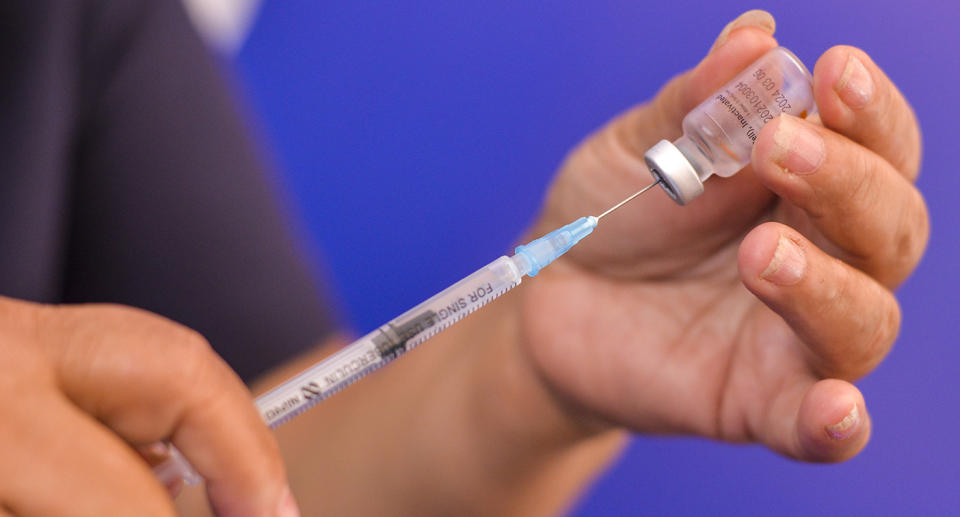 A health worker prepares a dose of the coronavirus vaccine.