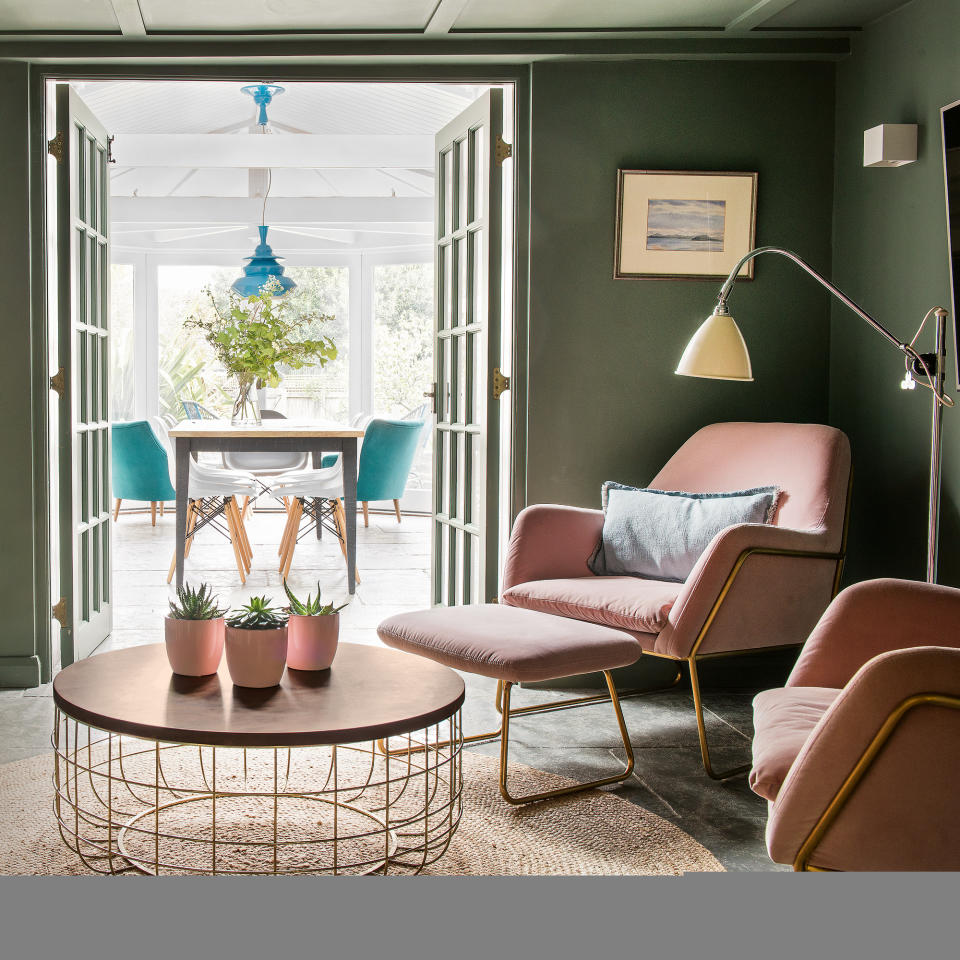 Green living room with pink armchairs