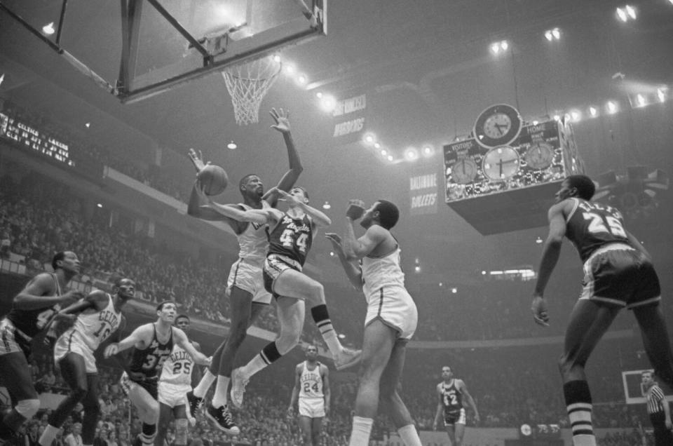 Lakers' Jerry West is guarded closely by the Celtics' Bill Russell.