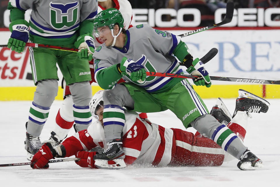 Carolina Hurricanes' Andrei Svechnikov (37) tangles with Detroit Red Wings' Dennis Cholowski (21) during the first period of an NHL hockey game in Raleigh, N.C., Saturday, April 10, 2021. (AP Photo/Karl B DeBlaker)
