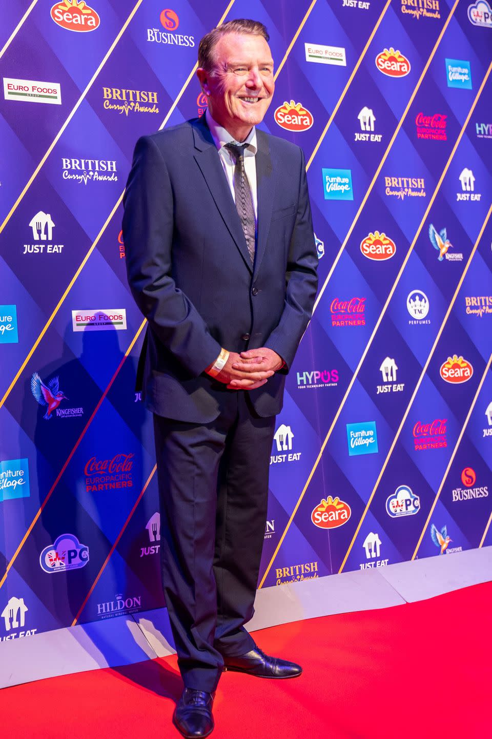 phil tufnell in a suit on a red carpet in 2022