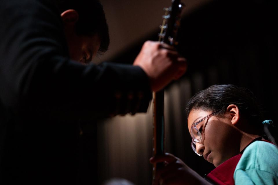 Instructor Adolfo Estrada, of San Antonio, tunes the instrument of Esmeralda Robledo, 12, from Premont, before a mariachi camp performance at Robstown High School, on Thursday, June 29, 2023, in Texas.