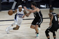 Orlando Magic's Markelle Fultz (20) heads to the basket as Brooklyn Nets' Joe Harris (12) and Timothe Luwawu-Cabarrot (9) defend during the first half of an NBA basketball game Friday, July 31, 2020, in Lake Buena Vista, Fla. (AP Photo/Ashley Landis, Pool)