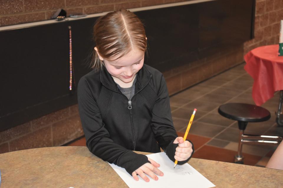 Addison Elementary first grader Jozie Curtis, 7, works on spelling out words while participating in a literacy night program offered for Addison Community Schools students Tuesday at Addison Middle/High School. The literacy night was conducted by Adrian College elementary teacher education students.