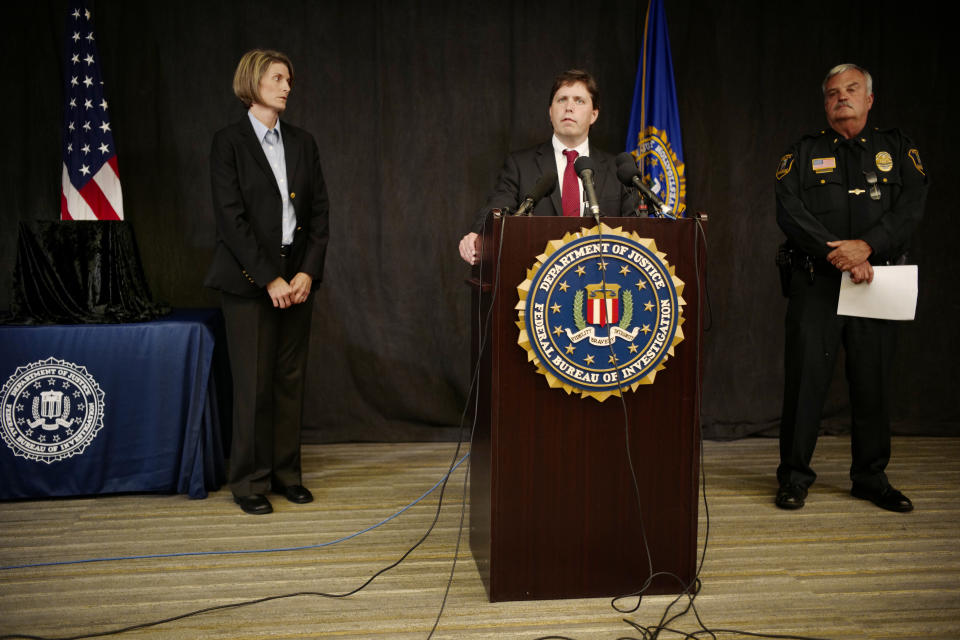 FBI Special Agent Jill Sanborn, left, and Grand Rapids Police Chief Scott Johnson, right, listen as U.S. Attorney Christopher Myers speaks during a news conference, Tuesday, Sept. 4, 2018, at the FBI office in Brooklyn Center, Minn., regarding the recovery of pair of ruby slippers once worn by actress Judy Garland in the "The Wizard of Oz." Authorities announced that the slippers, stolen in 2005 from the Judy Garland Museum in Grand Rapids, Minn., were recovered in a sting operation. The FBI says it has multiple suspects in the extortion and that the investigation continues. Four pairs of ruby slippers worn by Garland in the movie are known to exist. (Richard Tsong-Taatarii/Star Tribune via AP)