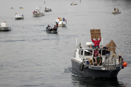 People protest on boats near a an open-water net pen during a flotilla against the expansion and renewal of Atlantic salmon net pens in Washington state at Rich Passage off Bainbridge Island, Washington, U.S. September 16, 2017. REUTERS/Jason Redmond