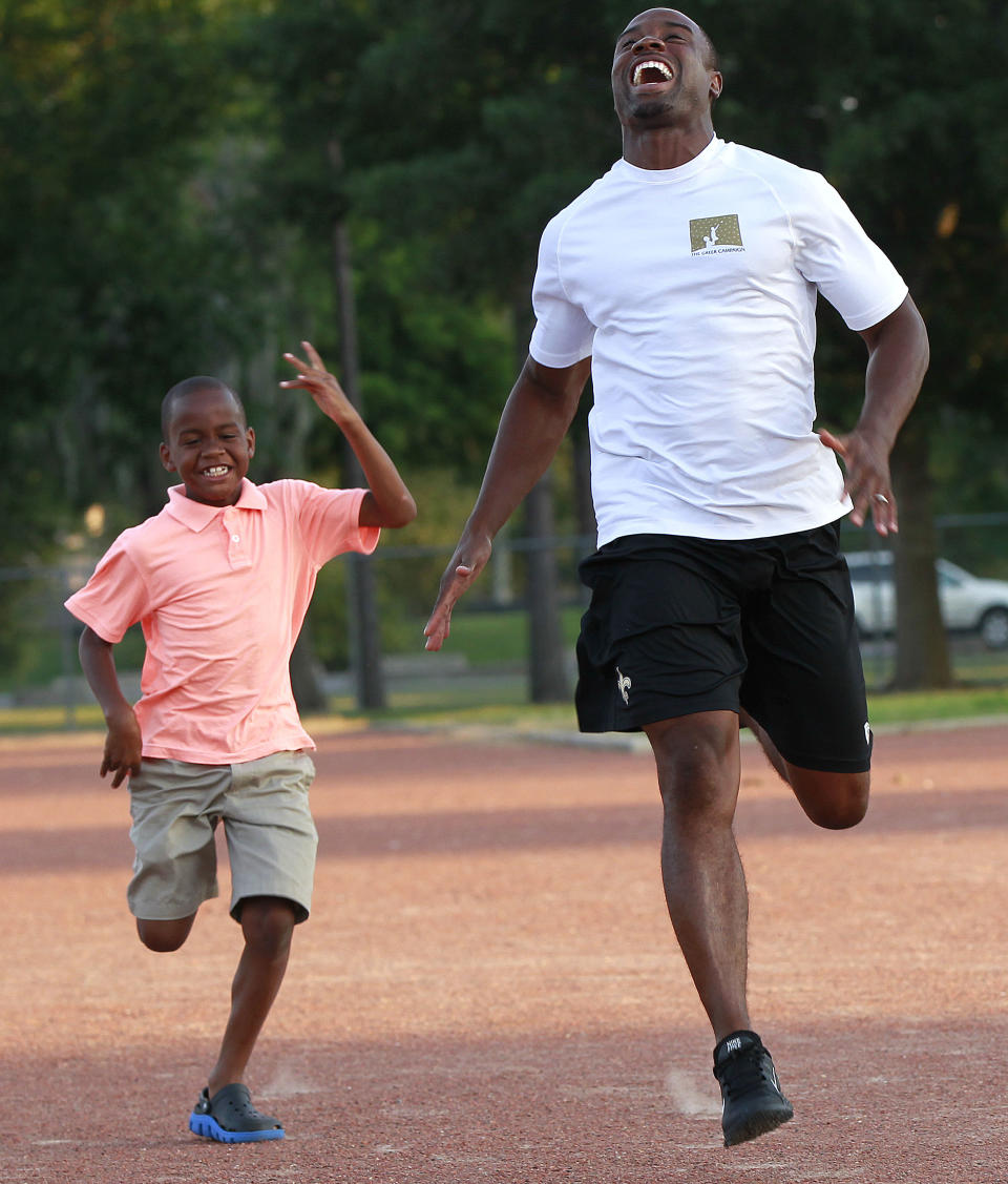 New Orleans Saints cornerback Jabari Greer, right, runs with his son Jeremiah Greer, 8, at Wally Pontiff Playground in Metairie, La., Wednesday, June 13, 2012. Fathers Day has a special meaning Greer, who's spending the weekend in the Tennessee town where he grew up throwing footballs and batting baseballs with his dad, Donny. His dad-focused nonprofit, the Greer Campaign, is hosting a 5K run, concert and street march on Saturday in Jackson, Tenn. to celebrate fathers and their importance to the well-being of their children. (AP Photo/Gerald Herbert)