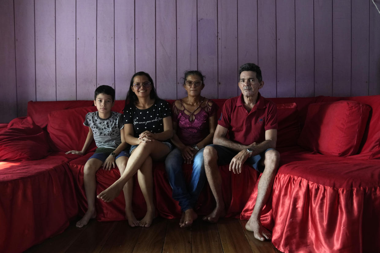 Members of the fishing community, Antonio Moura Da Cunha, poses with his family, from left, grandchild Jonnathan Cunha Dos Santos, daughter Quilvilene Figueiredo Da Cunha and wife Irlene Das Gracas da Cunha Figueiredo in San Raimundo settlement, Carauari, at Medio Jurua Region, Amazonia State, Brazil, Sunday, Sept. 4, 2022. In Sao Raimundo region, there were 1,335 pirarucus in the nearby lakes in 2011, when the managed fishing began. Last year, there were 4,092 specimens, according to their records. (AP Photo/Jorge Saenz)