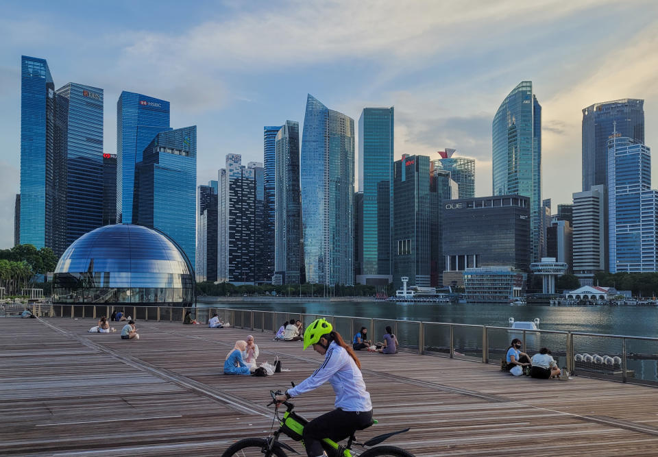 People relax on an outdoor deck as the sun sets in Marina Bay in Singapore on Monday, 14 June, 2021. Singapore begins to roll back a month of lockdown measures as average daily local COVID-19 cases come down from a May spike. Strict restrictions that disallow dining in at all food establishments and limit social interaction to groups not larger than 2 are expected to be rolled back in a week's time.  (Photo by Joseph Nair/NurPhoto via Getty Images)