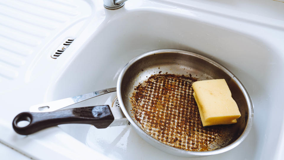 A pan with burnt-on food in a kitchen sink