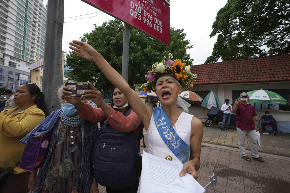 Cambodian-American lawyer Theary Seng, dressed in a pageant costume that reads "Lady Justice", shouts slogans outside Phnom Penh Municipal Court in Phnom Penh, Cambodia, Tuesday, May 3, 2022. Tuesday is the the final day of hearings for her trial on treason and a related charge for which she could receive a prison sentence of up to 12 years. (AP Photo/Heng Sinith)