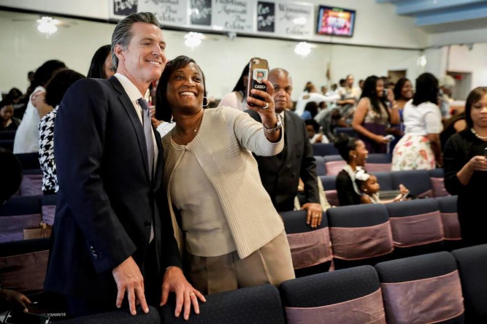 California democratic candidate for governor, Lt. Gov Gavin Newsom, takes a selfie with Laphonza Butler, president of SEIU local 2015, before speaking at Greater Zion Church in Compton on June 3, 2018.