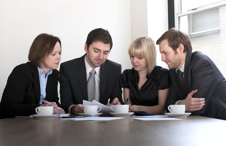 Four people have a discussion during a meeting