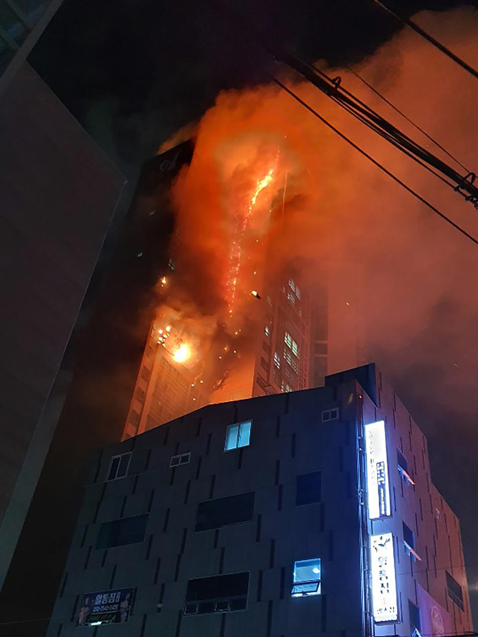 An apartment building is engulfed in a fire in Ulsan, South Korea, Friday, Oct. 9, 2020. A fire spread through the high-rise apartment building in the city early Friday, causing minor injuries to scores of people, officials said. (Lee Sang-hyun/Yonhap via AP)