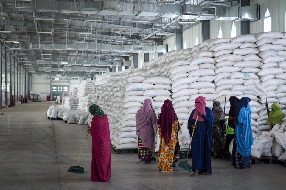 FILE - Workers clean the floor as sacks of food earmarked for the Tigray and Afar regions sits in piles in a warehouse of the World Food Programme (WFP) in Semera, the regional capital for the Afar region, in Ethiopia on Feb. 21, 2022. In 2023 urgently needed grain and oil have disappeared again for millions caught in a standoff between Ethiopia's government, the United States and United Nations over what U.S. officials say may be the biggest theft of food aid on record. (AP Photo, File)