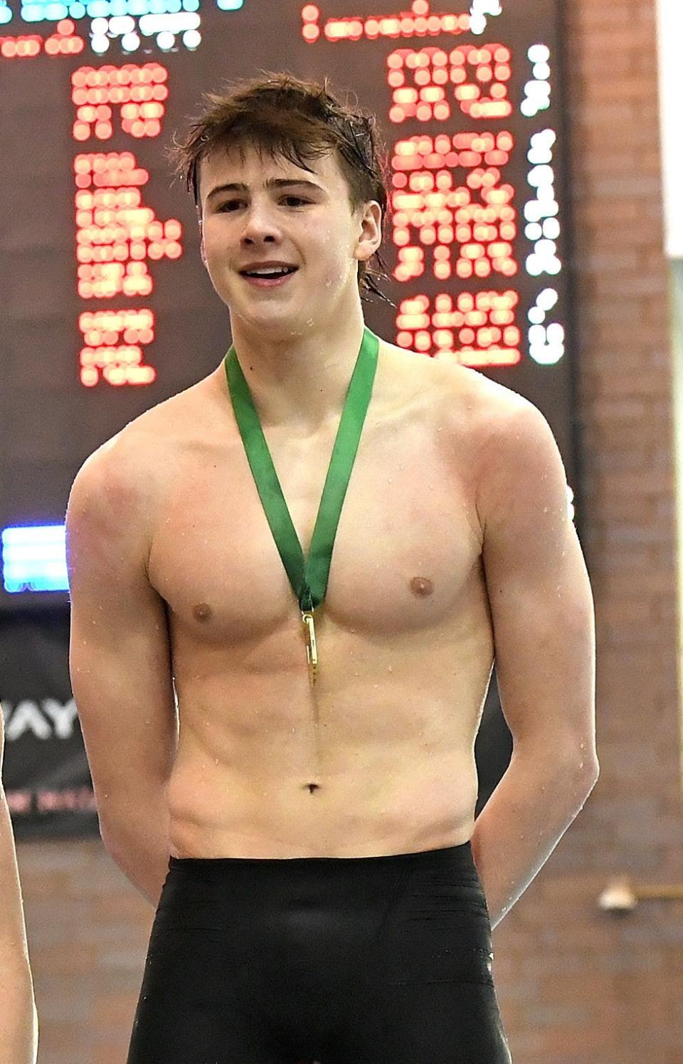 Jake Lloyd of St. Charles wears his first place medal atop the podium having won the boys 50 yard freestyle at the Feb. 24, 2024, Ohio High School Athletic Association Division I state swimming and diving meet in Canton, Ohio.