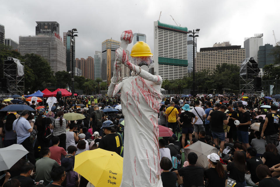 A replica of the Goddess of Democracy is displayed, wearing hard hat, gas mask, handcuffs and covered in a red liquid during a protest rally in Hong Kong on Sunday, Aug. 18, 2019. A spokesman for China's ceremonial legislature condemned statements from U.S. lawmakers supportive of Hong Kong's pro-democracy movement, as more protests were planned Sunday following a day of dueling rallies that highlighted the political divide in the Chinese territory. (AP Photo/Vincent Thian)