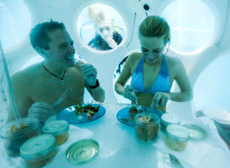 Belgians Florence Lutje Spelberg and Nicolas Mouchart have dinner while sitting inside "The Pearl", a spheric dining room placed 5 metres underwater in the NEMO33 diving center, one of the world's deepest pools (33 metre/36 yards) built to train professional divers, in Brussels, Belgium January 30, 2017. Picture taken January 30, 2017 REUTERS/Yves Herman