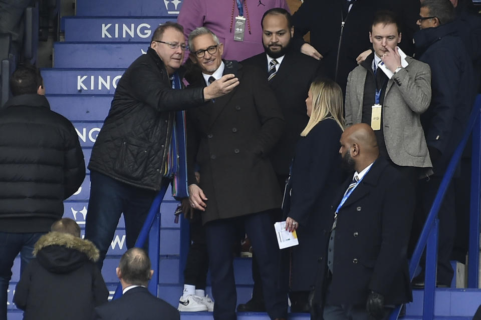 BBC's Match of the Day presenter Gary Lineker poses with a fan for selfies in the stands prior to the English Premier League soccer match between Leicester City and Chelsea at King Power stadium in Leicester, England, Saturday, March 11, 2023. (AP Photo/Rui Vieira)