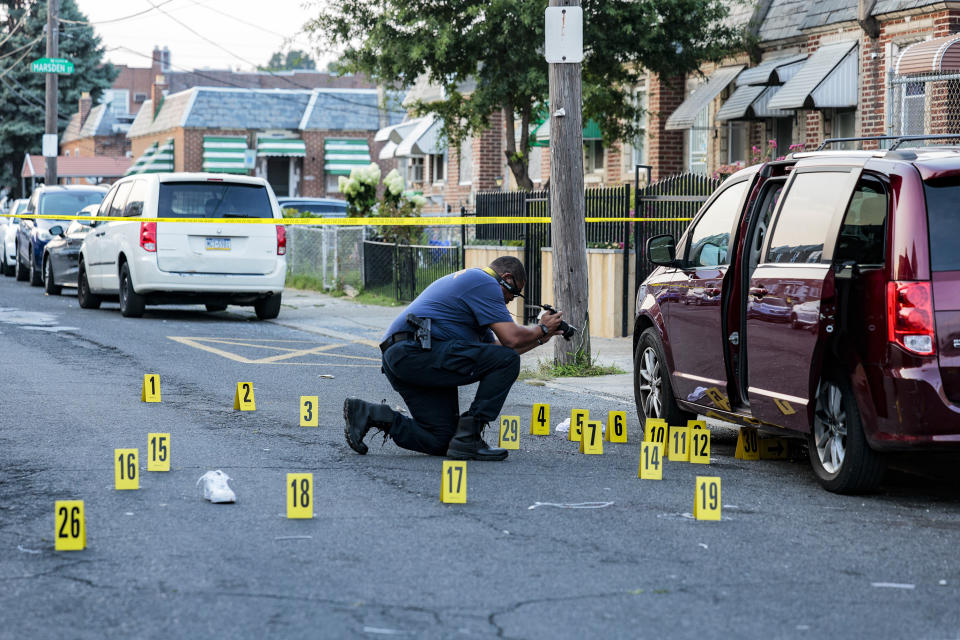 A Philadelphia police crime scene officer takes photos on the scene in Philadelphia, where a 27-year-old man was fatally shot Monday, Aug. 21, 2023. More than 25 shell casings were found at the scene. (Steven M. Falk/The Philadelphia Inquirer via AP)