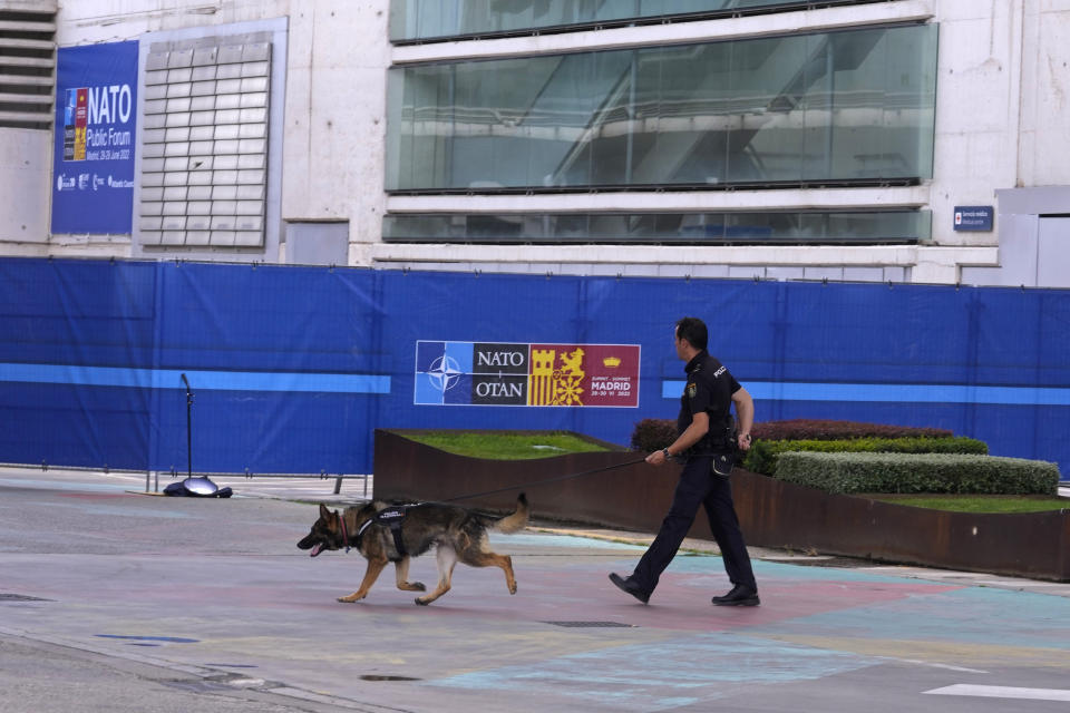 FILE - A police officer patrols with a sniffer dog outside the NATO Summit building ahead of next week's summit in Madrid, Spain, June 25, 2022. Russia’s invasion of Ukraine is certain to dominate an upcoming NATO summit in Madrid. But host nation Spain and other members are quietly pushing the Western alliance to consider how mercenaries aligned with Russian President Vladimir Putin are spreading Moscow’s influence in Africa. (AP Photo/Paul White, File)