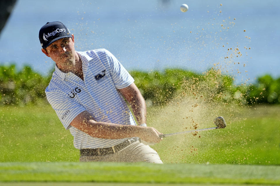 J.T. Poston hits from the bunker on the 17th green during the final round of the Sony Open golf event, Sunday, Jan. 14, 2024, at Waialae Country Club in Honolulu. (AP Photo/Matt York)