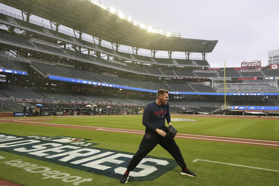 Atlanta Braves first baseman Freddie Freeman warms up in the rain before Game 3 of baseball's World Series between the Houston Astros and the Atlanta Braves Friday, Oct. 29, 2021, in Atlanta. (AP Photo/Brynn Anderson)