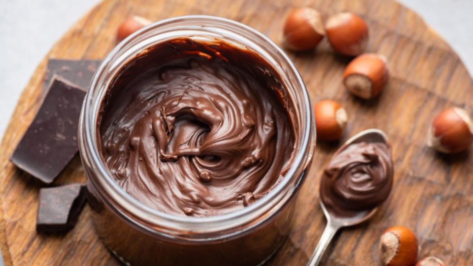 homemade chocolate hazelnut spread in jar on cutting board