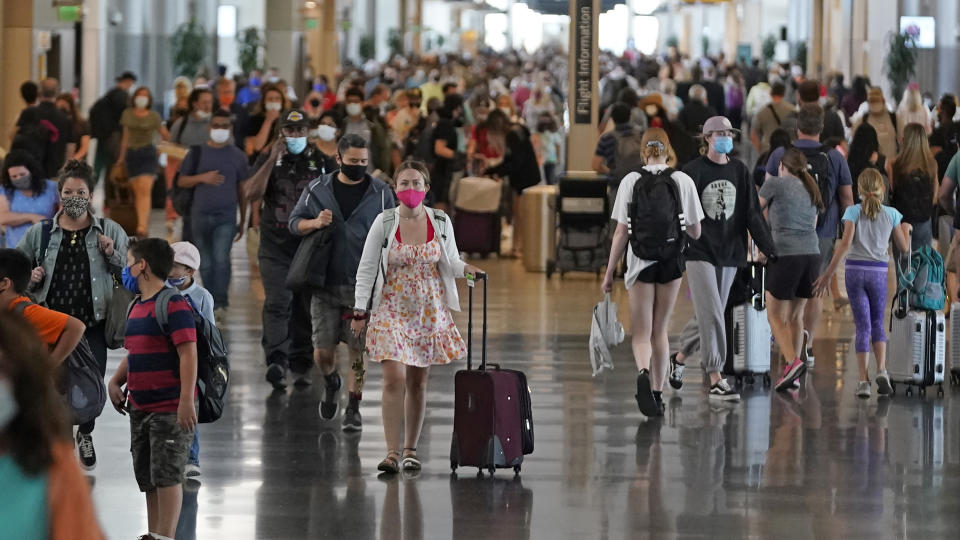 FILE - In this Thursday, July 1, 2021 file photo, people walk through Salt Lake City International Airport in Salt Lake City. This summer is already shaping up to be a difficult one for air travelers as airlines are already struggling to keep up with the rising number of passengers. (AP Photo/Rick Bowmer, File)