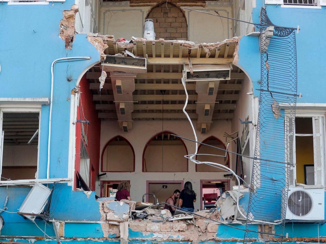 A Lebanese couple inspect the damage to their house in an area overlooking the destroyed Beirut port on 5 August 2020: Joseph Eid/AFP via Getty Images