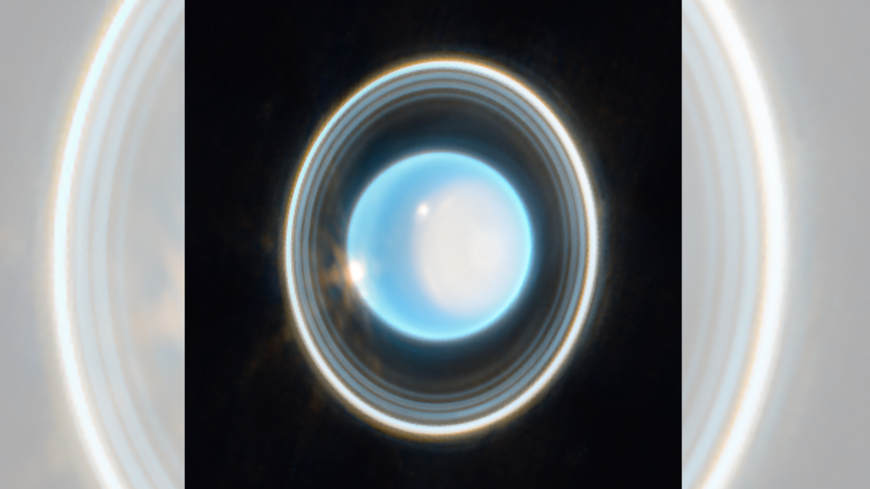  Uranus, the 7th planet from the sun, appears as a shiny blue ball surrounded by white rings in this James Webb Space Telescope image 