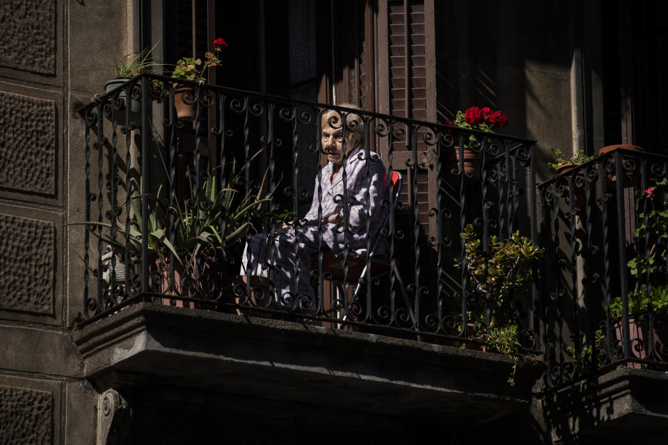 A woman sits on her balcony in downtown Barcelona, Spain, May 7, 2020. The image was part of a series by Associated Press photographer Emilio Morenatti that won the 2021 Pulitzer Prize for feature photography. (AP Photo/Emilio Morenatti)