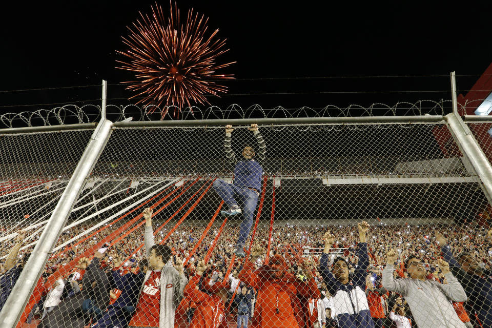 Fans of Argentina's Independiente cheer during a Copa Libertadores quarterfinal soccer match against River Plate in Buenos Aires, Argentina, Wednesday, Sept. 19, 2018. (AP Photo/Natacha Pisarenko)