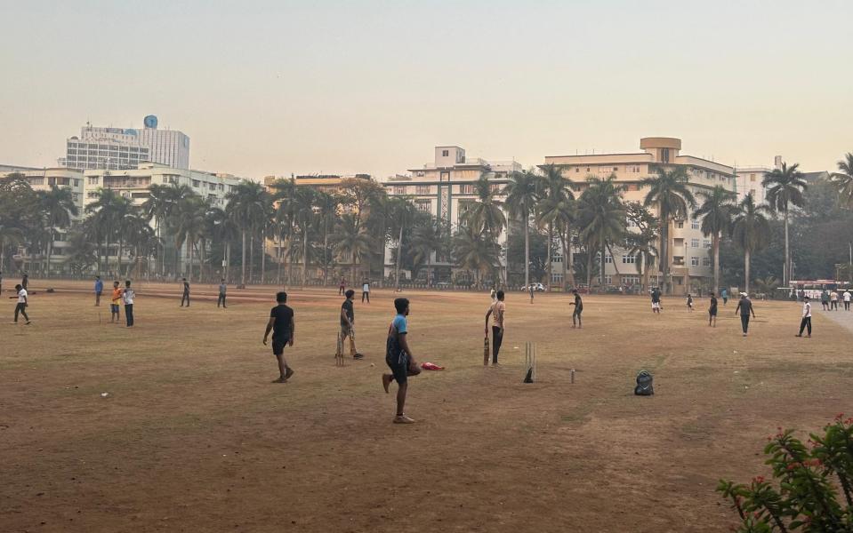 Kids play cricket on a dusty field in India